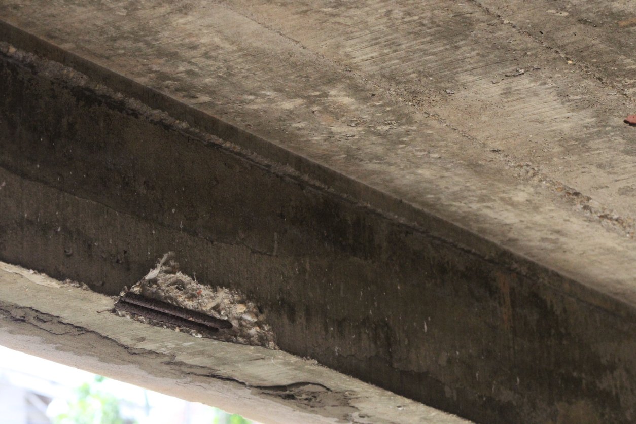 Concrete spalling damage on the underside of a bridge