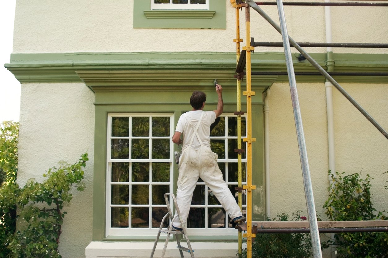 Professional completing a maintenance painting contract