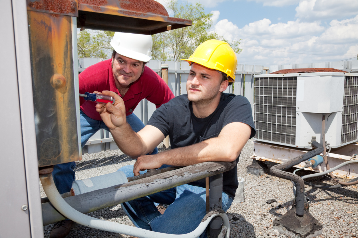 HVAC professionals completing school maintenance tasks to protect the building